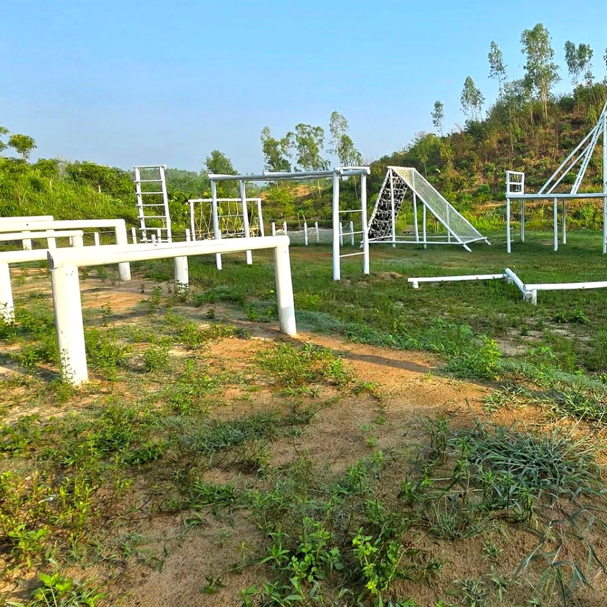 Outdoor ground obstacle course with balance beams, ladders and cargo net at Tongkaboti Nature Retreat.