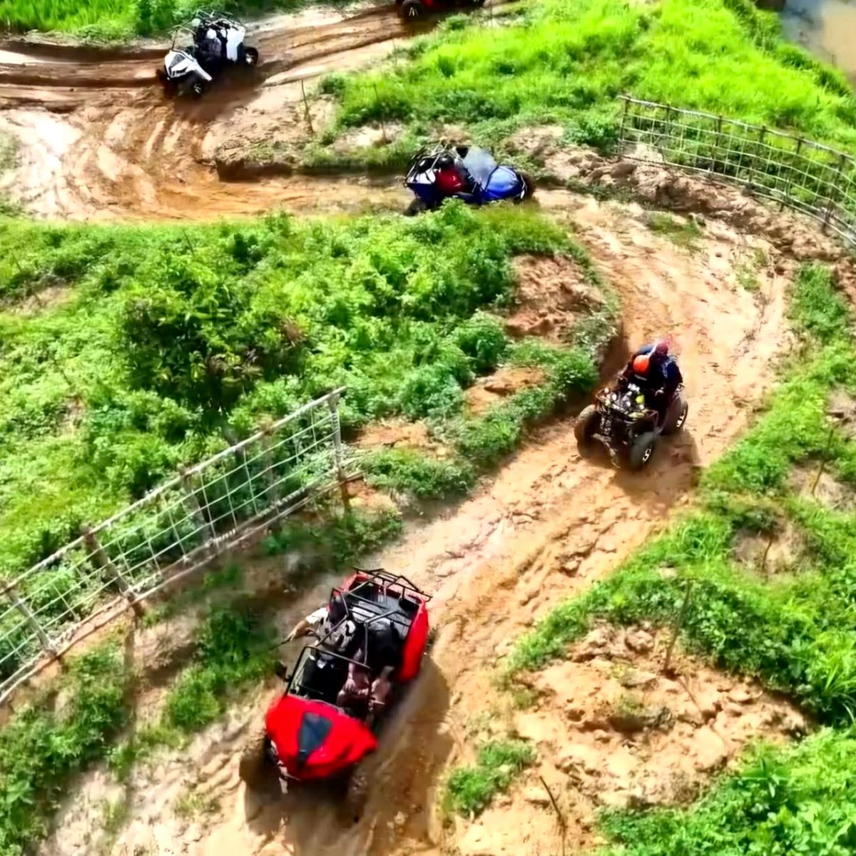 ATVs and UTVs riding the muddy hillside adventure trail at Tongkaboti Nature Retreat.